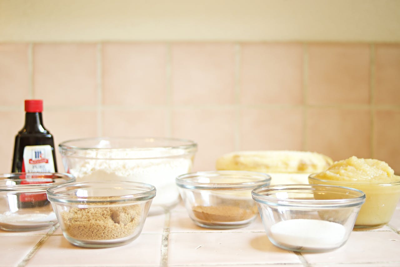 Glass bowls with baking ingredients on a kitchen counter, ideal for baking projects.